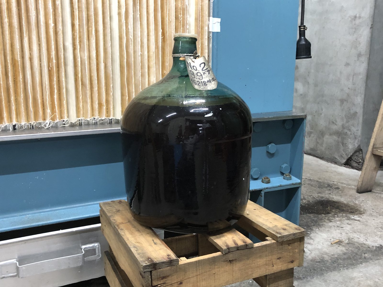 緑色のガラスの斗瓶。首に「No.2 3.9kg」と書かれた札が結ばれ、中の酒は黒に近い琥珀色